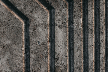 Relief gray reinforced concrete wall with curved extruded stripes.