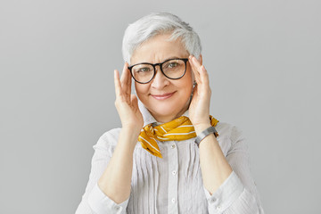 Age, optics, eyewear and vision concept. Smiling good looking elegant retired mature female having...