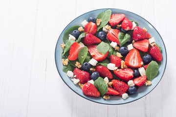 Summer Strawberry salad with spinach , cheese , nuts and blueberry