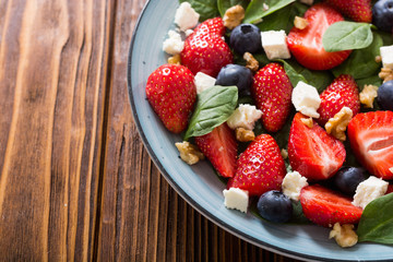 Summer Strawberry salad with spinach , cheese , nuts and blueberry