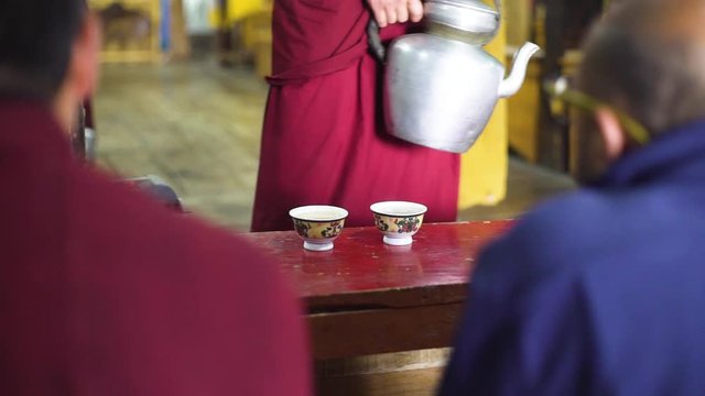 Close up tight shot as poring milk tea on the Puja, morning ceremony in a buddhist monastery