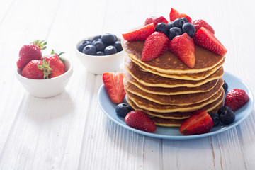 Tasty pancakes with blueberry and strawberry