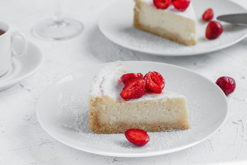 Cheesecake decorated with strawberries on a white plate