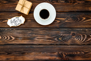 cup of coffee, gift and copy for Happy Father Day party on wooden background top view copy space