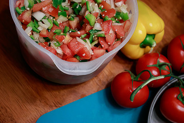 bright blue cutting bored under salsa and fresh tomatos and peppers