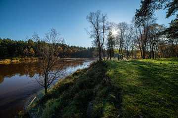 dramatic dark red clouds in sunset over countryside fields and forests