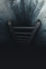 Verschwindende Leiter die in einen dunklen Bunker führt