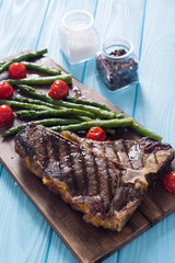 Grilled T-bone steak with asparagus and cherry tomatoes
