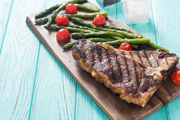 Grilled T-bone steak with asparagus and cherry tomatoes