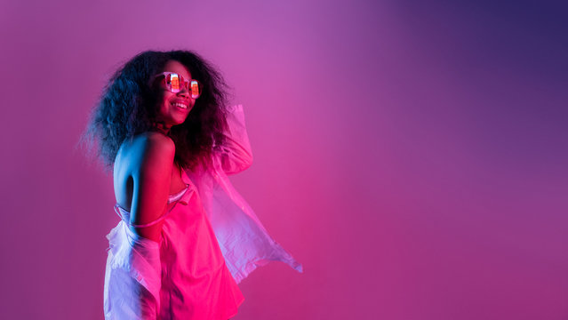 Happy Smiling Fashion Young African Girl Black Woman Wear Stylish Glasses Raincoat Looking At Camera Isolated On Disco Party Purple Studio Background, Banner For Website Design, Portrait, Copy Space