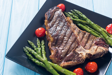 Grilled T-bone steak with asparagus and cherry tomatoes