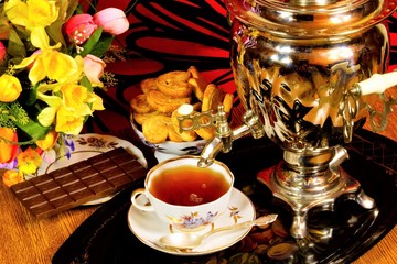Tea party - samovar, sweet dessert cookies and fragrant confectionery chocolate, Russian traditions.  Samovar — a metal vessel for boiling water and making tea on a tray with Goodies, on a creative ba