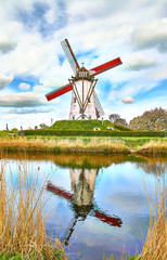 reflection of windmill in damme, near bruges, belgium