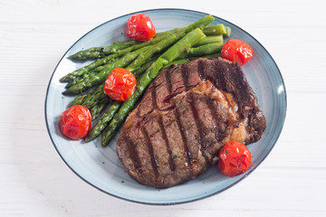 Grilled beef steak ribeye with cherry tomatoes and asparagus