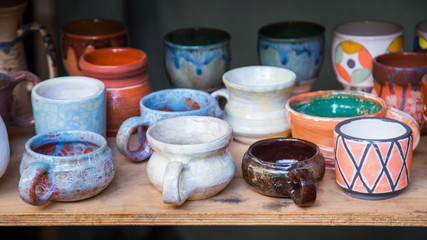 Different clay jugs, cups and pots at art souvenir market. Handmade, creative and handicraft concept