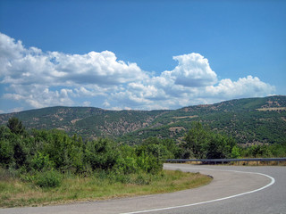 Empty road in the southern hilly-mountainous area on a hot summer day.