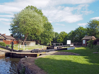 the exit lock gates at brighouse basin on the calder and hebble navigation canal with 19th century lock keepers building