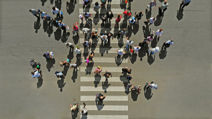 Aerial. People crowd on pedestrian crosswalk. Top view.
