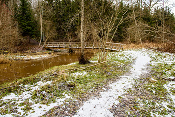 wet damp hiking tourist trail with snow leftovers on the sides