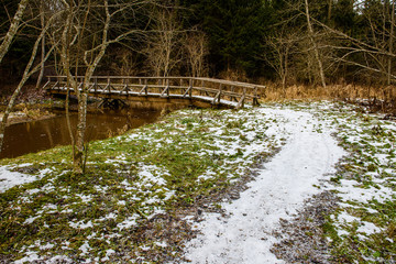 wet damp hiking tourist trail with snow leftovers on the sides