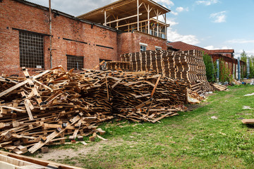 Old abandoned and ruined industrial building with many wooden pallets near