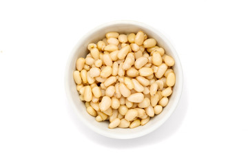 Pine nut in ceramic bowl on white background, top view
