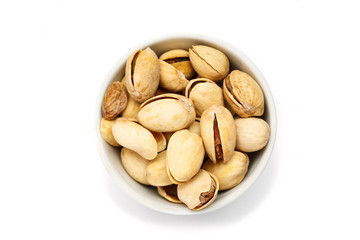 Pistachio in ceramic bowl on white background, top view