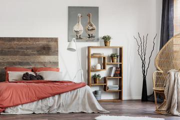 Rustic poster with two ducks, wooden bookshelf and double bed with pillows and duvet
