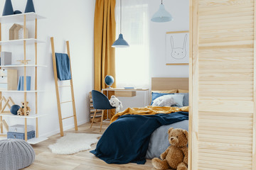 Messy kid's bedroom with toys and wooden furniture real photo