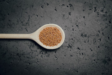 Mustard on a stone table. The concept of using seasonings for dishes. Strengthening the taste through spices, better cooking and better taste of dishes.