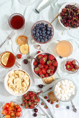 Summer berries strawberries, blueberries, sweet cherries in vases on the table. Top view