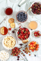 Summer berries strawberries, blueberries, sweet cherries in vases on the table. Top view