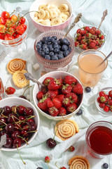 Summer berries strawberries, blueberries, sweet cherries in vases on the table. Top view