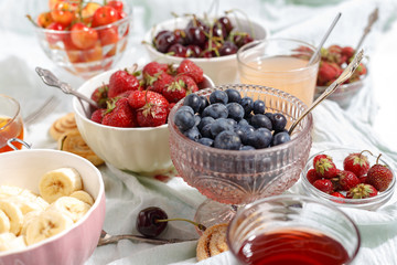 Summer berries strawberries, blueberries, sweet cherries in vases on the table. Top view