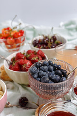 Summer berries strawberries, blueberries, sweet cherries in vases on the table. Top view