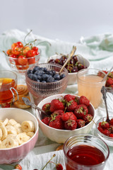 Summer berries strawberries, blueberries, sweet cherries in vases on the table. Top view
