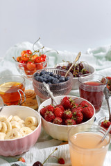 Summer berries strawberries, blueberries, sweet cherries in vases on the table. Top view