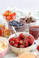 Summer berries strawberries, blueberries, sweet cherries in vases on the table. Top view