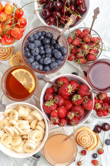 Summer berries strawberries, blueberries, sweet cherries in vases on the table. Top view