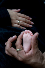 manos de papas modelando pie de bebe 