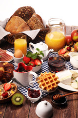Huge healthy breakfast on table with coffee, orange juice, fruits, waffles and croissants. Good morning concept.