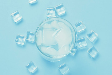 Glass of refreshing cold water with ice and ice cubes on a blue background. Concept of thirst,...