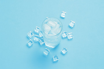 Glass of refreshing cold water with ice and ice cubes on a blue background. Concept of thirst,...