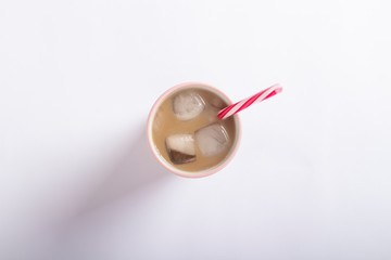 Refreshing and invigorating coffee with ice in a glass on a light white background. Concept coffee shop, quenching thirst, summer. Flat lay, top view