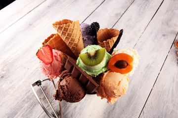 ice cream scoops of different colors and flavours with berries, nuts and fruits decoration on white...