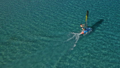 Aerial photo of surfer cruising in high speed in Mediterranean destination bay with deep blue sea