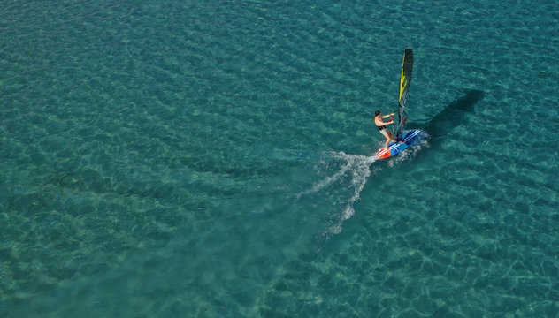 Aerial photo of surfer cruising in high speed in Mediterranean destination bay with deep blue sea © aerial-drone