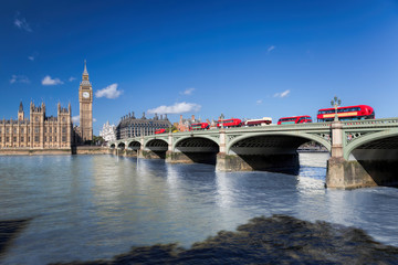 Fototapeta na wymiar Big Ben and Houses of Parliament with red buses on the bridge in London, England, UK