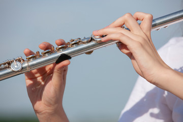 Girl playing the flute in the garden.