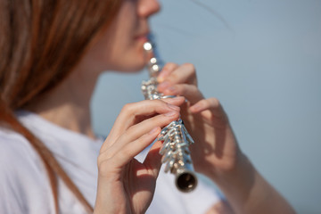 Girl playing the flute in the garden. © biggur